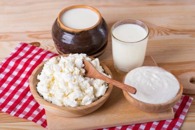 süzme peynir, süt ve ekşi krema ahşap bir masada. Farklı süt ürünleri: peynir, krema, süt, yoğurt.