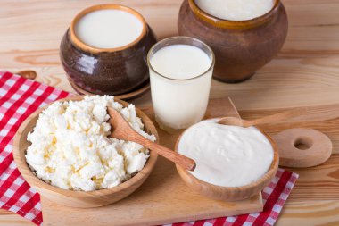 süzme peynir, süt ve ekşi krema ahşap bir masada. Farklı süt ürünleri: peynir, krema, süt, yoğurt.