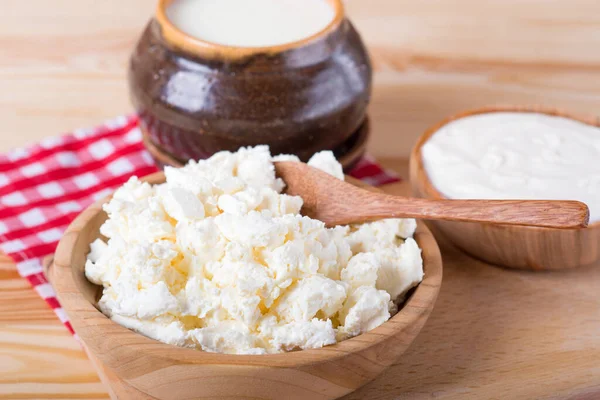 cottage cheese, milk and rustic sour cream on a wooden table. Sour cream