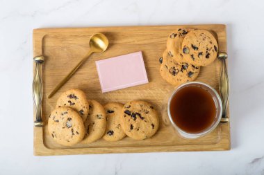 Tahta tepsi ve yatakta hafif kahvaltı. Kurabiye ve kahve tepsisi. Yatakta kahvaltı