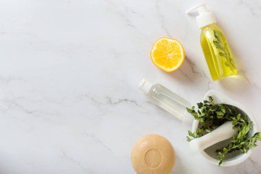 Limon kozmetik ürünleri, sabun ve krema beyaz masada. Limonlu sağlık, limon banyosu, organik sabun, tuz fırçası, yağ, kozmetik krem, duş jeli ve limonlu spa.
