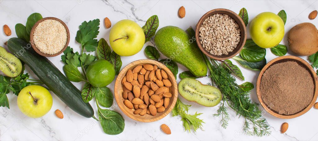 Healthy food clean eating selection: fruit, vegetable, seeds, superfood, cereal, leaf vegetable on gray concrete background