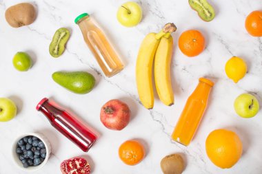 Gri masa üzerinde taze meyve suyu şişeleri, üst görünüm