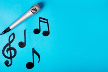 Müzik konsepti. müzik notaları ve mikrofon mavi arkaplanda.