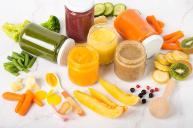 Ev yapımı bebek sebze ve meyve püresi çeşitliliği, beyaz mermer arka plan fotokopi alanı üst görünüm