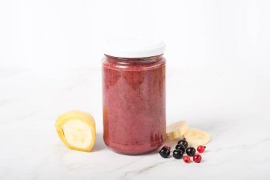 Kavanozda muzlu bebek böğürtlen püresi. Doğal bebek maması konsepti: taze eriklerin yanındaki masada erik aromalı elma püresi kavanozu