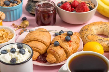 Fransız kahvaltısı. Pembe arka planda kruvasanlar. Yaklaş. Ön manzara. Sarı Arkaplan.