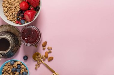 Fransız kahvaltısı. Müsli ve kahve pembe arka planda böğürtlenli.