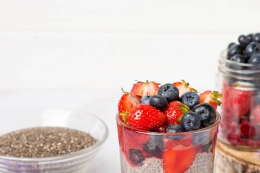 Chia tohumları beyaz üzerine puding. böğürtlenli ve çiçekli puding