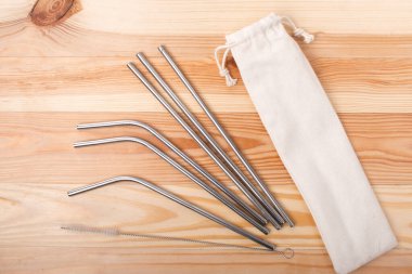 Beyaz kopya alanı olan cam kavanozda paslanmaz çelik pipetler.