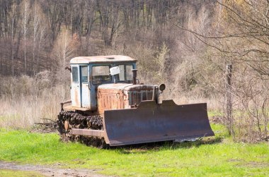 Çim tarlasında eski bir traktör. eski traktör