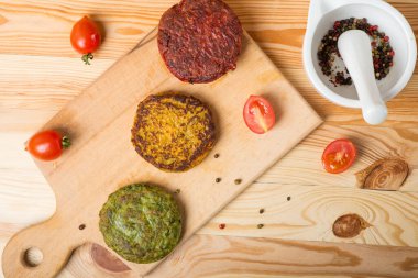 Vejetaryen pirzolası. Sebzeleri karıştır. Hamburgerler, köfteler, pirzola. Açık beyaz ahşap arka plan. Üst manzara. Düz yatıyordu.