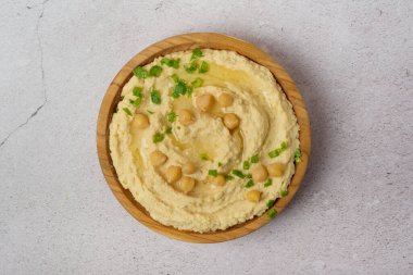 Gri arka planda nohut humusu. Bir kase taze humus.