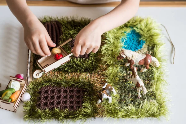 Material Montessori. Las manos de los niños juegan una figura animal. granja de juego para niños —  Fotos de Stock