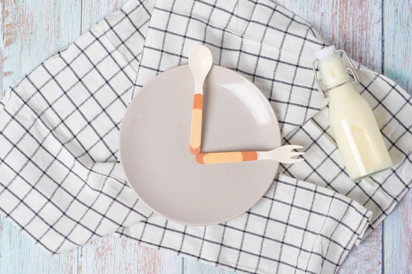 Time for baby food. clock spoon and fork on a plate — Stock Photo, Image