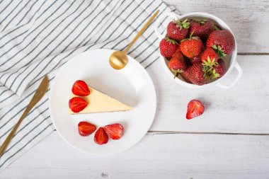 Peynirli kek. Beyaz masada çilekli klasik cheesecake.