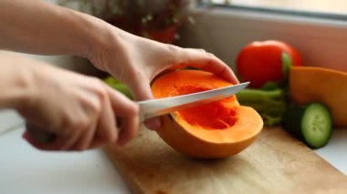 woman slicing pumpkin on board