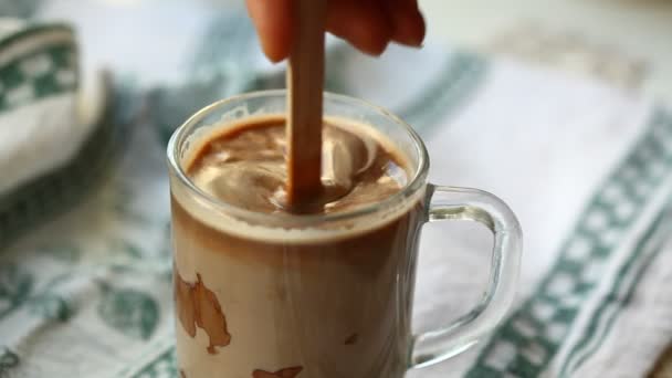 Mano mezclando chocolate en una leche caliente — Vídeos de Stock