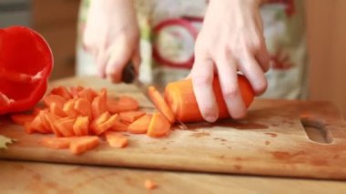 woman's hand slicing carrot