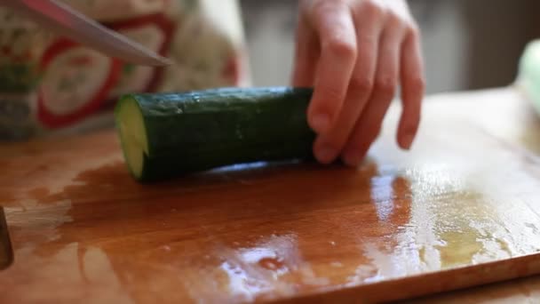 Vrouwelijke handen hakken komkommer — Stockvideo