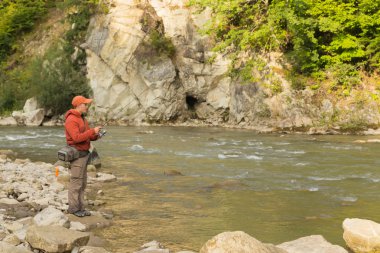 Balıkçı bir dağ nehir üzerinde egzotik balık yakalamak. Alabalık balıkçılık Karpat nehirler. Dağları nın el değmemiş doğası. Balıkçılık ve doğal dergiler, posterler ve Web siteleri için fotoğraf.