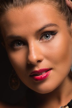 Şık makyaj ve aksesuarları karanlık bir arka plan üzerinde güzel bir esmer.