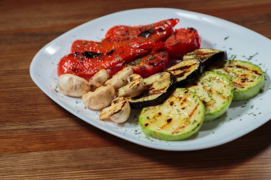 Beyaz tabakta lezzetli çeşitli ızgara sebze.