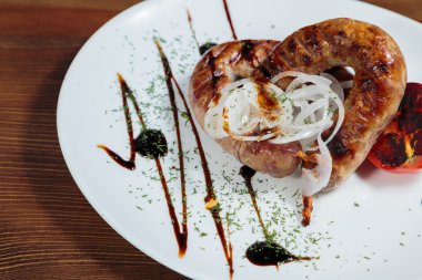 Izgarada pişirme. Izgara sosis kızartma. Izgara menü. Domuz sosisi bir plaka üzerinde.