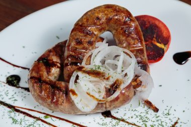 Izgarada pişirme. Izgara sosis kızartma. Izgara menü. Domuz sosisi bir plaka üzerinde.