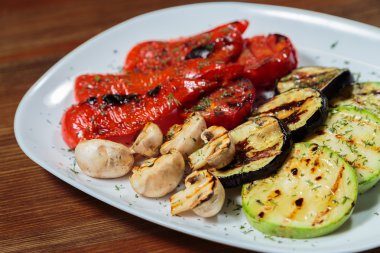 Beyaz tabakta lezzetli çeşitli ızgara sebze.