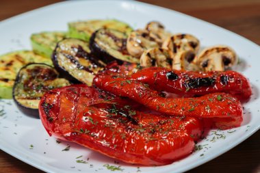 Beyaz tabakta lezzetli çeşitli ızgara sebze.