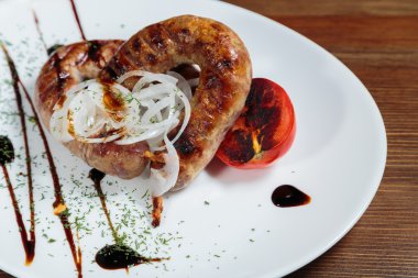 Izgarada pişirme. Izgara sosis kızartma. Izgara menü. Domuz sosisi bir plaka üzerinde.