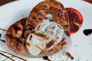 Izgarada pişirme. Izgara sosis kızartma. Izgara menü. Domuz sosisi bir plaka üzerinde.