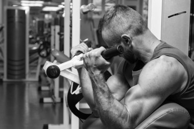 Atlet pazı simülatör spor salonunda tezgah. El kas eğitim simülatör. Gergin kasları el yük altında. Fotoğraflar spor dergileri, afiş ve Web siteleri için.