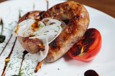 Izgarada pişirme. Izgara sosis kızartma. Izgara menü. Domuz sosisi bir plaka üzerinde.