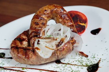 Izgarada pişirme. Izgara sosis kızartma. Izgara menü. Domuz sosisi bir plaka üzerinde.