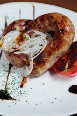 Izgarada pişirme. Izgara sosis kızartma. Izgara menü. Domuz sosisi bir plaka üzerinde.