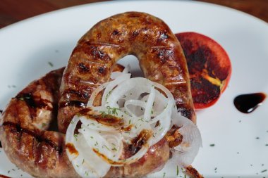 Izgarada pişirme. Izgara sosis kızartma. Izgara menü. Domuz sosisi bir plaka üzerinde.