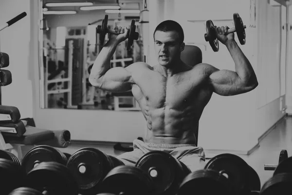 Hombre en el gimnasio. El hombre hace ejercicios con barra . — Foto de Stock