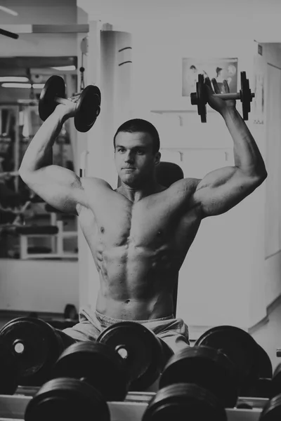 Hombre en el gimnasio. El hombre hace ejercicios con barra . — Foto de Stock