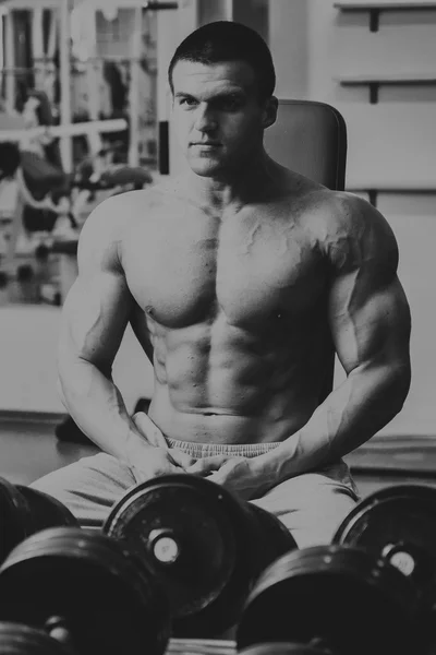 Hombre en el gimnasio. El hombre hace ejercicios con barra . — Foto de Stock