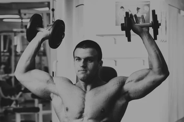 Hombre en el gimnasio. El hombre hace ejercicios con barra . —  Fotos de Stock