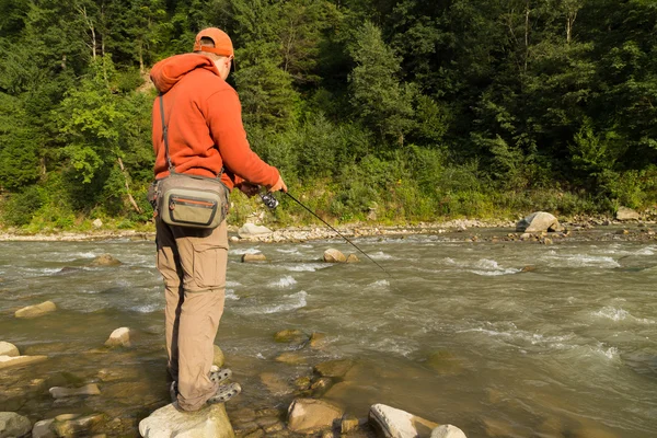 Balıkçı bir dağ nehir üzerinde egzotik balık yakalamak. Alabalık balıkçılık Karpat nehirler. Dağları nın el değmemiş doğası. Balıkçılık ve doğal dergiler, posterler ve Web siteleri için fotoğraf.