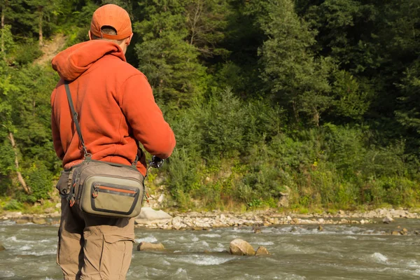 Pescatore su un fiume di montagna cattura pesci esotici. Pesca della trota nei fiumi Carpazi. Natura incontaminata delle montagne. Foto per la pesca e riviste naturali, manifesti e siti web . — Foto Stock