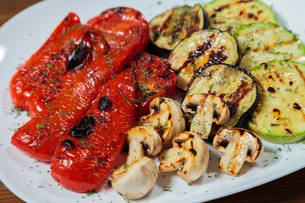 Beyaz tabakta lezzetli çeşitli ızgara sebze.