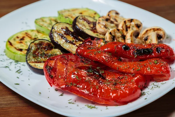 Vegetais grelhados saborosos e variados em um prato branco . — Fotografia de Stock