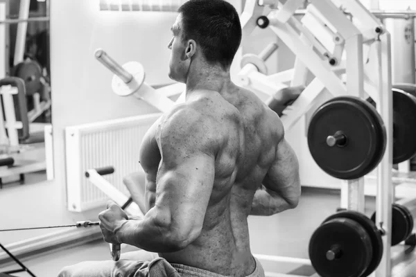 Strong muscular man doing exercises in the gym. — Stock Photo, Image