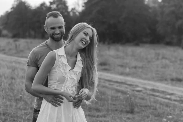 Schwarz-Weiß-Foto-Biker-Paar auf einem Motorrad im Feld. — Stockfoto