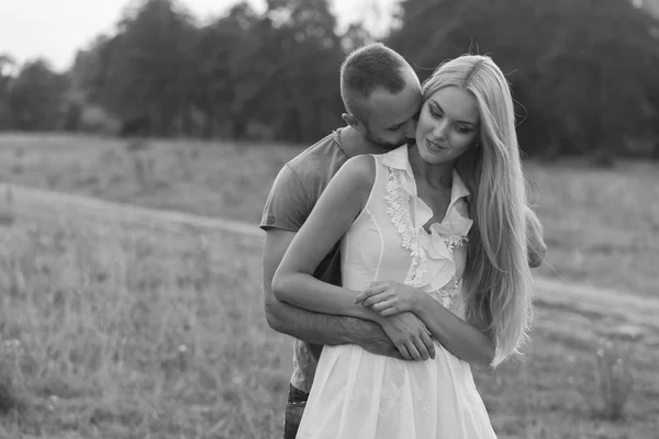 Blanco y negro foto motorista pareja en una motocicleta en el campo . — Foto de Stock