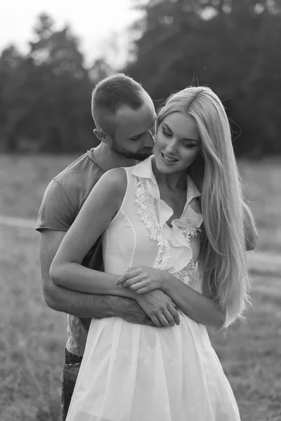 Black and white photo biker couple on a motorcycle in the field.